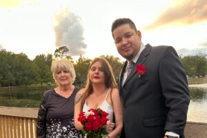 A man and woman standing next to a young girl.